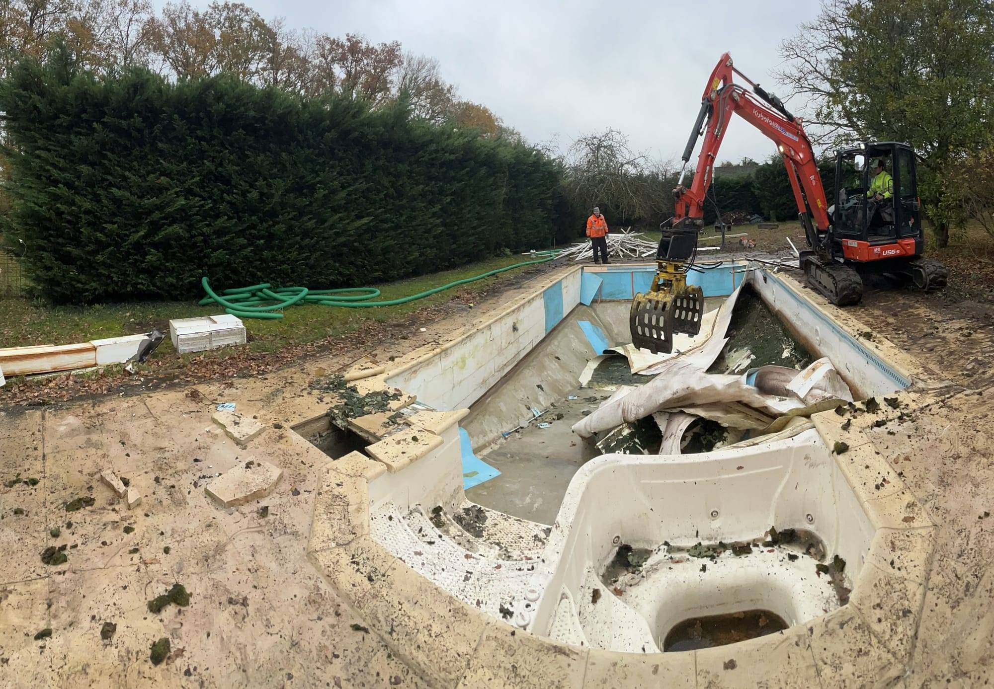 Démolition d’une piscine à Maslives : démolition du bassin à la pelle.